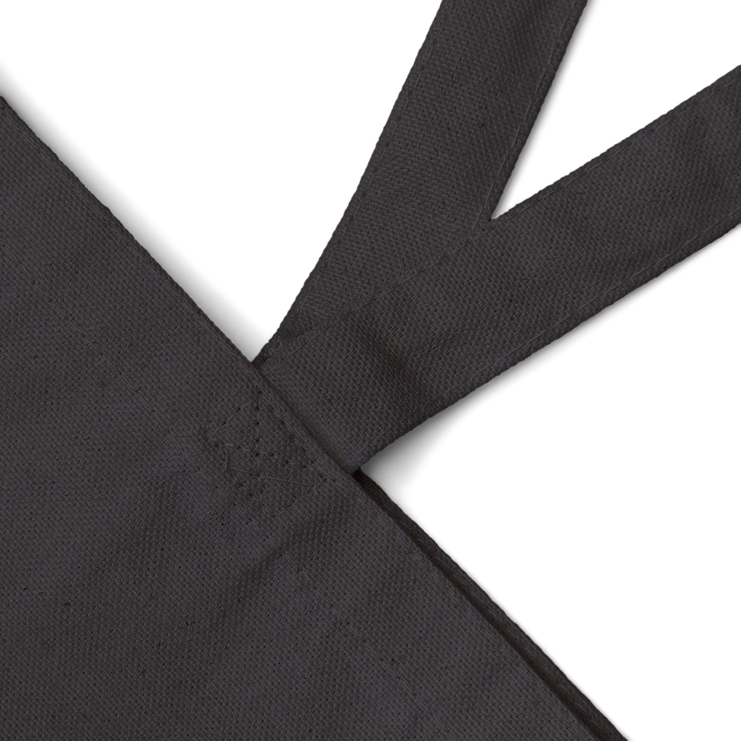 Halloween cut out faces peer out of a Black Cotton Canvas Tote Bag by artist Marie Frederique
