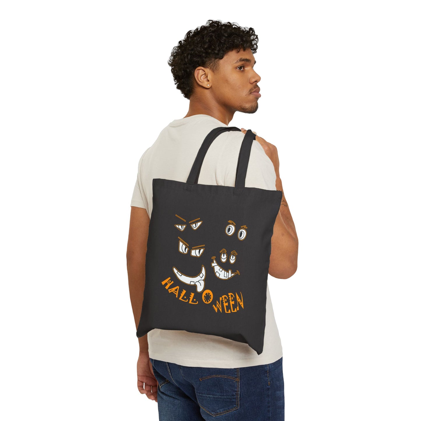 Halloween cut out faces peer out of a Black Cotton Canvas Tote Bag by artist Marie Frederique